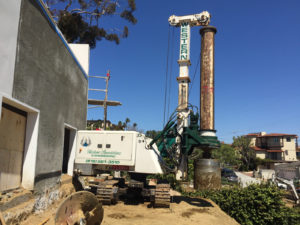 Western Foundations' drill caisson rig drilling on a slope, showcasing just one of our construction services.